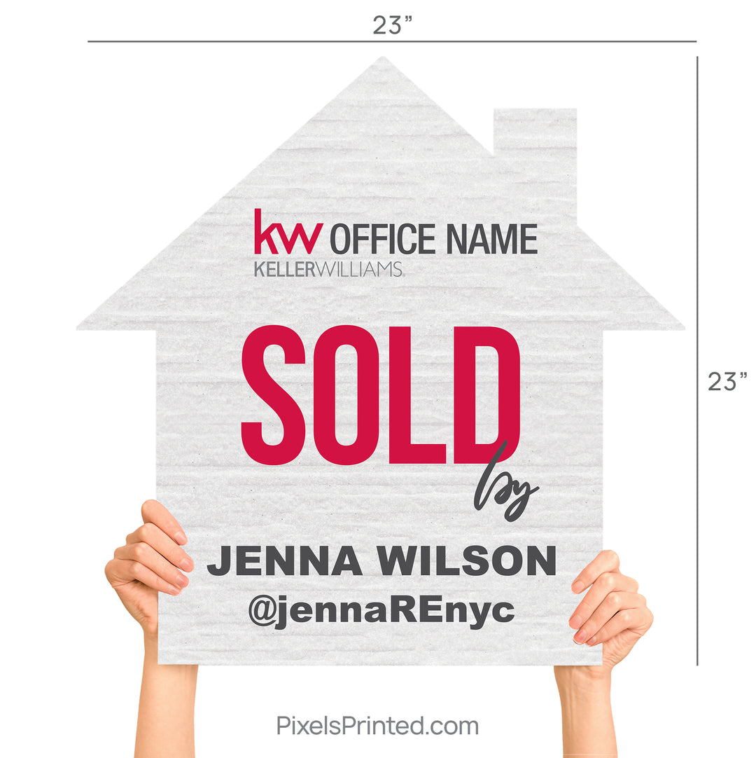 Close up of a modern house-shaped real estate sign saying Sold By in script lettering.